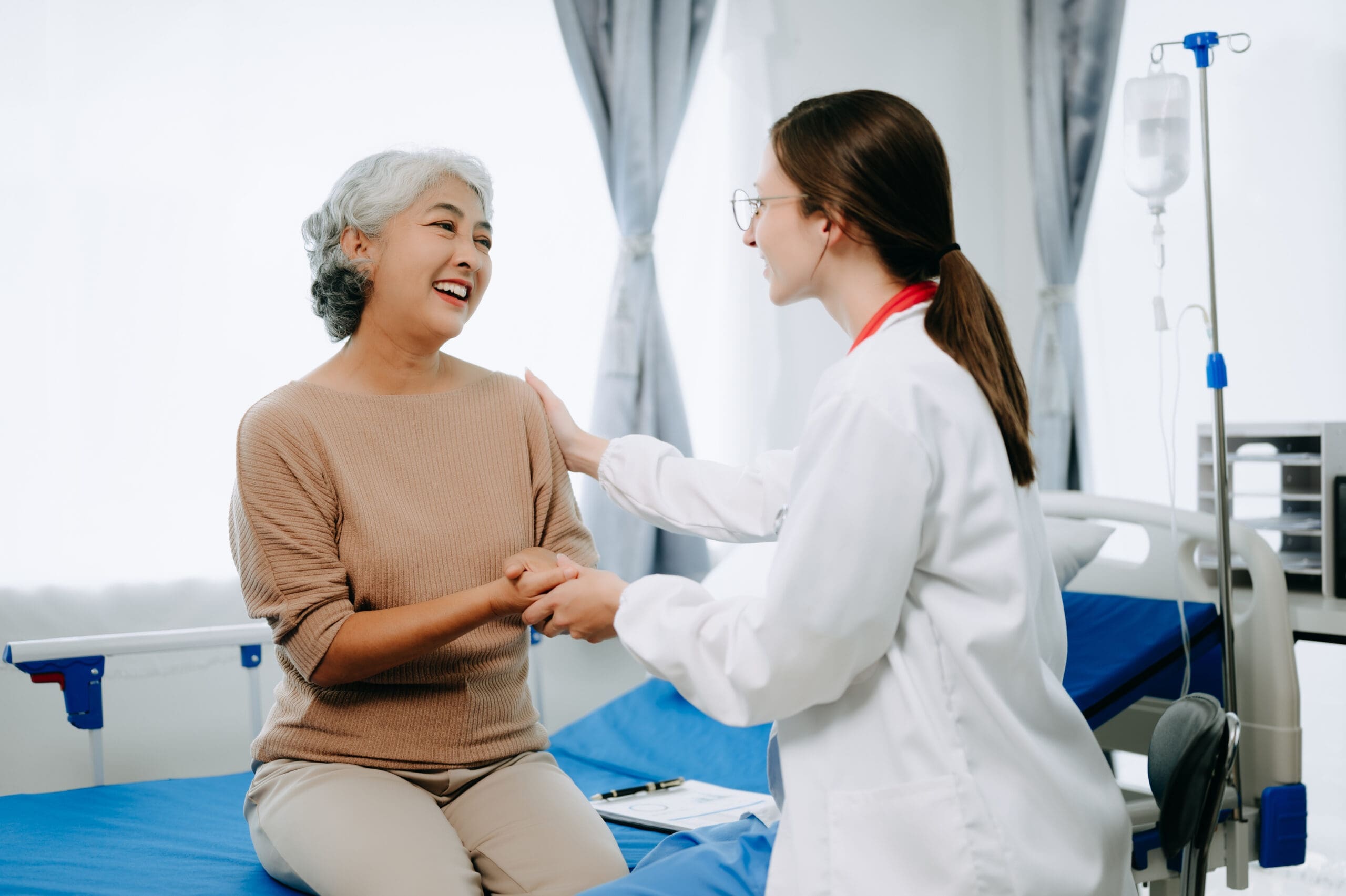 Friendly Female Head Nurse Making Rounds does Checkup on Patient